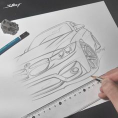 someone is drawing a car on paper with pencils