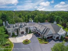 an aerial view of a large home surrounded by trees