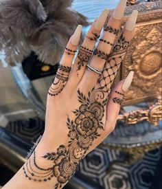 a woman's hand with henna tattoos on it