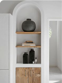 the shelves in this room have vases and books on them