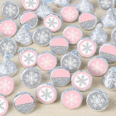 pink and silver snowflake candy wrappers on a wooden table with white frosting