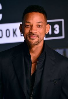 a man in a black suit posing for the camera