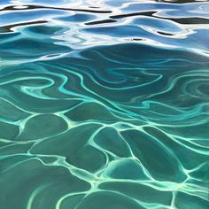 the water is very blue and green with some ripples on it's surface