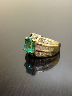 DeKara Designs Classic Handmade Art Deco Oval Emerald and Diamond Ring. Metal- 14K Yellow Gold, .583 Stones- 1 Emerald Cut Colombian Emerald 1.52 Carats, 18 Baguette Diamonds H-I, 16 Round Diamonds G-H Color VS2 Clarity 1.75 Carats. Size- 5 1/2. Free sizing. Art Deco Influenced Beautiful Colombian Emerald Diamond Engagement Ring. There is a beautiful 1.52 carat green emerald in the center of the ring that is emerald cut and expertly prong set. There are baguettes that are channel set on the side Diamond Emerald Engagement Ring, Art Deco Emerald, Emerald Ring Engagement Diamond, Emerald And Diamond Ring, Baguette Diamonds, Gold Art Deco, Colombian Emeralds, Emerald Engagement, Diamond Wedding Ring