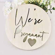 a wooden sign that says, we're pregnant with hearts on the front and back