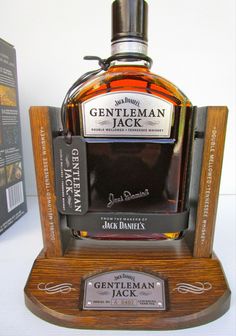 a bottle of jack daniels whiskey sitting on top of a wooden stand