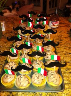 cupcakes decorated with the colors of italy and mustaches on top of them