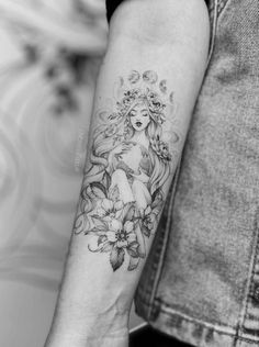 a woman's arm with flowers on it and an angel in the middle of her arm