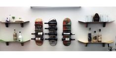 there are three skateboards mounted to the wall with wine bottles on them and two shelves