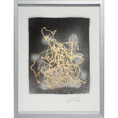 an abstract painting with gold paint on black and white paper, framed in a silver frame