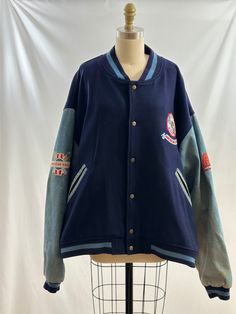 This vintage 90s American Eagle Outfitters jacket is so cool. Varsity style, it as wool body with denim sleeves and colorful embroidered patchwork on arms as well as the back.   -Vintage 90s -Wool and denim, colorful embroidered patchwork -Dry clean only Measurements:  marked a men's extra large *Sleeve 25 inches *Bust 29 inches *Length 26 1/2 inches *Bottom opening 25 1/2 inches *This item is pre-loved and there may be minor flaws to the garment. Not to worry if there is anything major we will Winter Cotton Varsity Jacket With Patchwork, Winter Cotton Outerwear With Embroidered Patch, 90s Style Patchwork Outerwear For Streetwear, Retro Cotton Varsity Jacket For Fall, Vintage Outerwear With Embroidered Patch For Winter, Fall Varsity Jacket With Embroidered Patch And Long Sleeves, Retro Cotton Outerwear With Patches, Fall Varsity Jacket With Embroidered Patch, Vintage Embroidered Patch Winter Outerwear