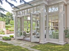 a large white house with many windows on the front and side doors open to let in lots of light