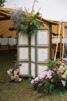 A rustic wedding seating chart display featuring a folding screen adorned with floral arrangements and seating cards. Summer Seating Chart, Micro Wedding Seating Chart, Winery Wedding Seating Chart, Seating Arrangement Wedding Display, Classic Seating Chart, Picture Frame Seating Chart Wedding, Unique Seating Chart Wedding Display, Garden Party Seating Chart, Interactive Wedding Seating Chart