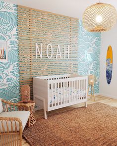 a baby's room with blue and white wallpaper, wicker crib, rattan chair, and rug