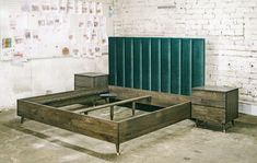 a bed frame with two drawers and a green headboard