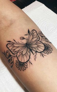 a black and white butterfly tattoo on the arm