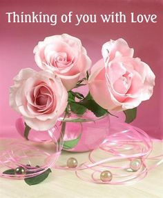 three pink roses in a glass vase with pearls