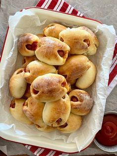 a white dish filled with pastries sitting on top of a red and white napkin