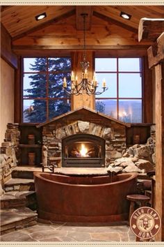 the interior of a log cabin with stone fireplace and jacuzzi tub in it