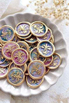 a white plate topped with lots of purple and gold buttons