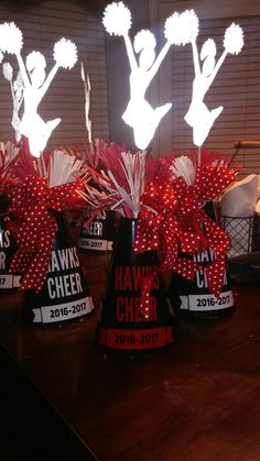 several hats with red bows on them sitting on top of a wooden table in front of a window