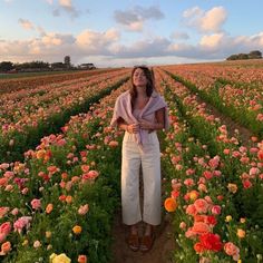 a woman standing in a field full of flowers