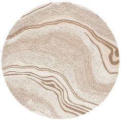 a round rug with wavy lines in beige and brown on the bottom, along with a white background