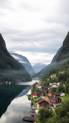 a small village on the shore of a lake surrounded by mountains