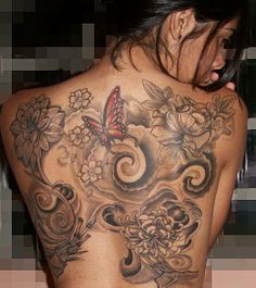 the back of a woman's body with tattoos on it