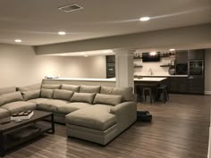 a living room filled with furniture next to a kitchen