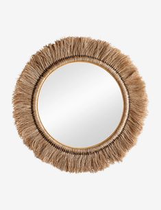 a round mirror with some kind of animal hair on the edge and a gold frame