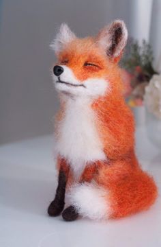 an orange and white stuffed fox sitting on top of a table