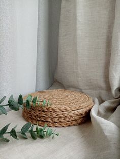 a stack of baskets sitting on top of a table next to a white cloth covered window