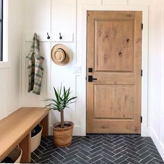 an entryway with a wooden door and potted plant