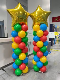 two star shaped balloons in the shape of stars are on display at an airport terminal