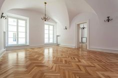 an empty room with wooden floors and chandeliers