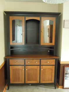 a large wooden cabinet with two mirrors on it's sides and drawers in the middle