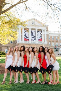 a group of women standing next to each other in front of a building