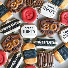 decorated cookies are arranged in the shape of bottles and numbers for 30th birthday party favors