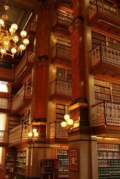 the inside of a library with many bookshelves and chandeliers hanging from the ceiling