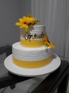 a white and yellow cake with sunflowers on top