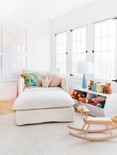 a living room filled with furniture and lots of window sill space next to a rocking horse