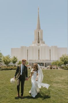 a bride and groom walking in front of the mormon temple