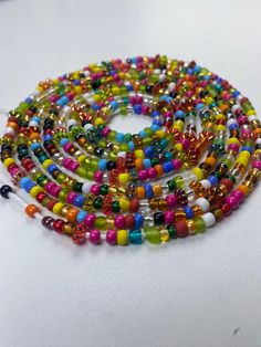 Brighten your life and wardrobe with our stunning Multicolored Waistbead. Handcrafted with love, each bead is carefully selected and strung to create a vibrant, eye-catching accessory that complements any outfit. Uses of the Multicolored Waistbead: • Fashion Statement: Wear it over or under your clothing to add a pop of color and a touch of elegance to your ensemble. • Body Awareness: Helps you stay mindful of your body, serving as a gentle reminder of your fitness and wellness journey. • Weight Bohemian Rainbow Heart Beads, Bohemian Colorful Spacer Beads, Colorful Bohemian Spacer Beads, Adjustable Multicolor Beaded Chain Waist Beads, Bohemian Rainbow Beaded Necklaces With Heart Beads, Bohemian Multicolor Beaded Bracelets With Heart Beads, Bohemian Rainbow Beaded Necklace With Heart Beads, Multicolor Beaded Chain Waist Beads For Festivals, Spiritual Multicolor Round Waist Beads