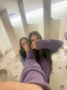 two women taking a selfie in the bathroom