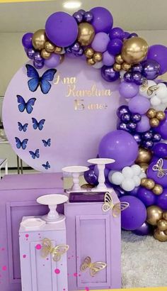 purple and gold balloon arch with butterflies on it