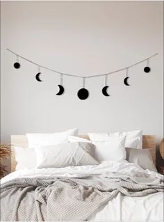 a bed with four phases of the moon hanging above it