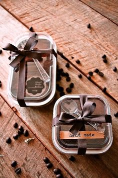 two glass containers filled with coffee beans on top of a wooden table