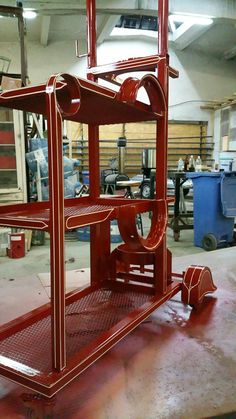 a red metal cart sitting inside of a garage