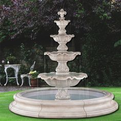 a water fountain sitting on top of a lush green field